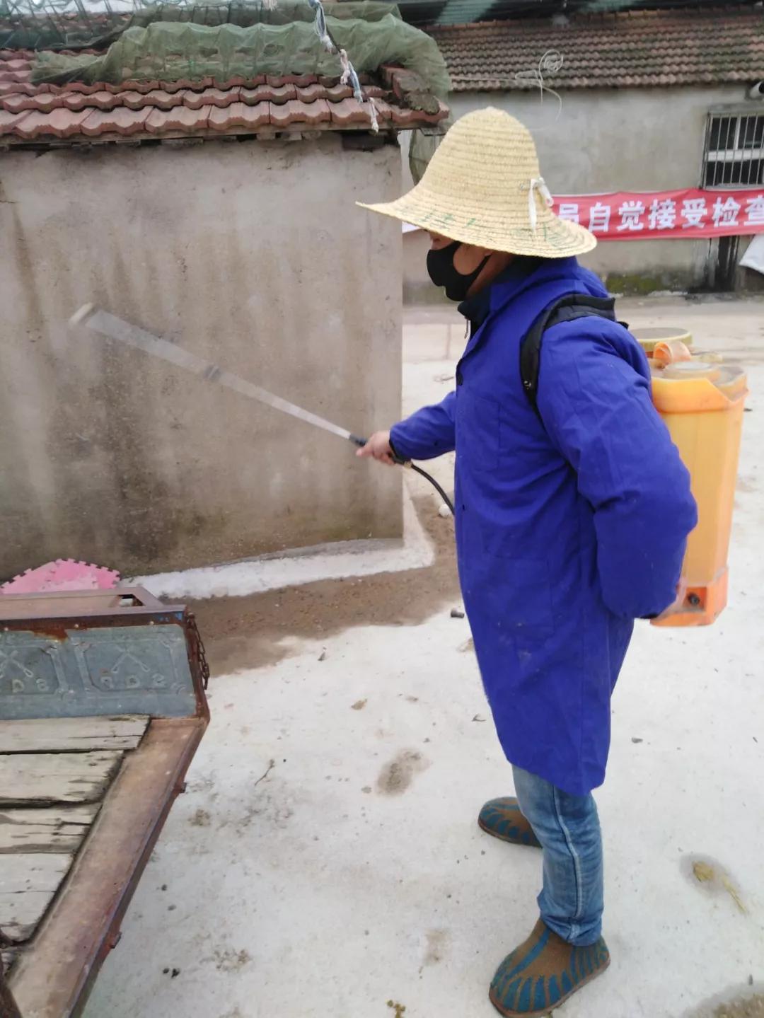 王文明正在對(duì)居戶(hù)門(mén)口進(jìn)行消毒